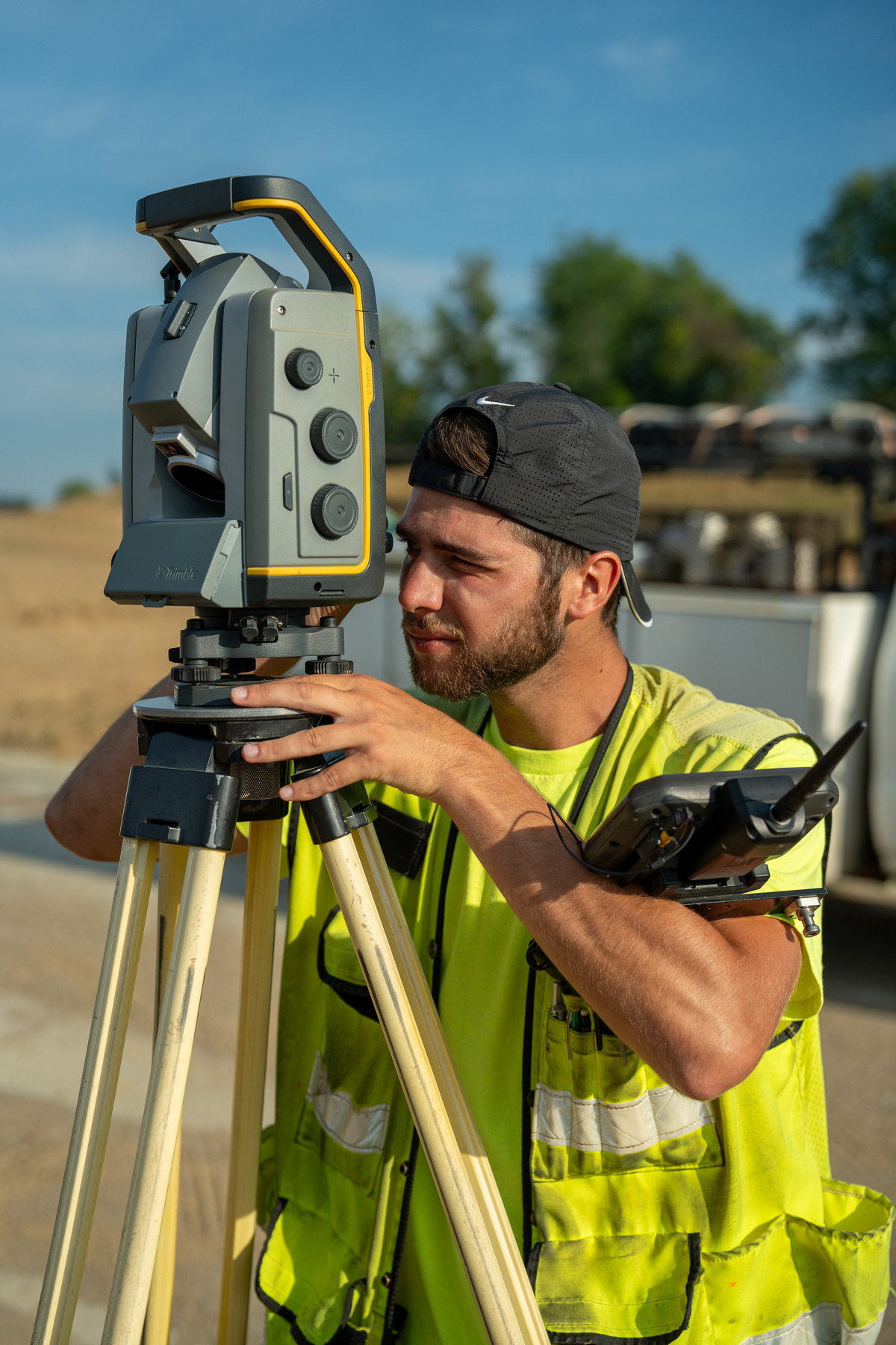 Bayer Becker Land Surveying Surveyor using equipment outdoors on a sunny day.
