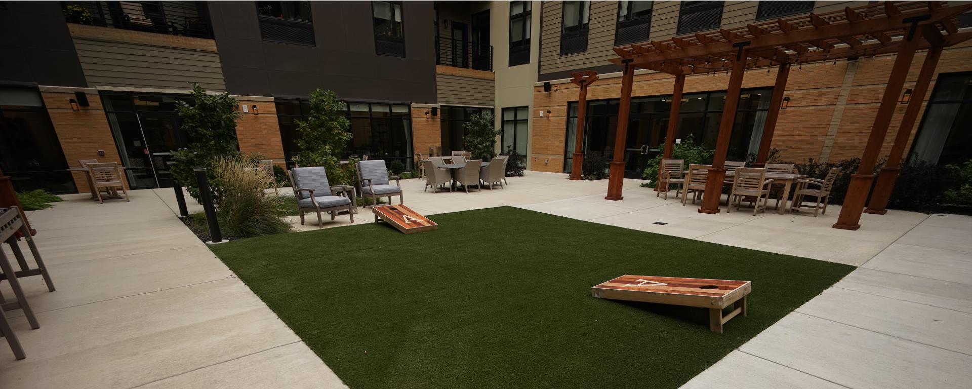 courtyard with cornhole boards on green grass