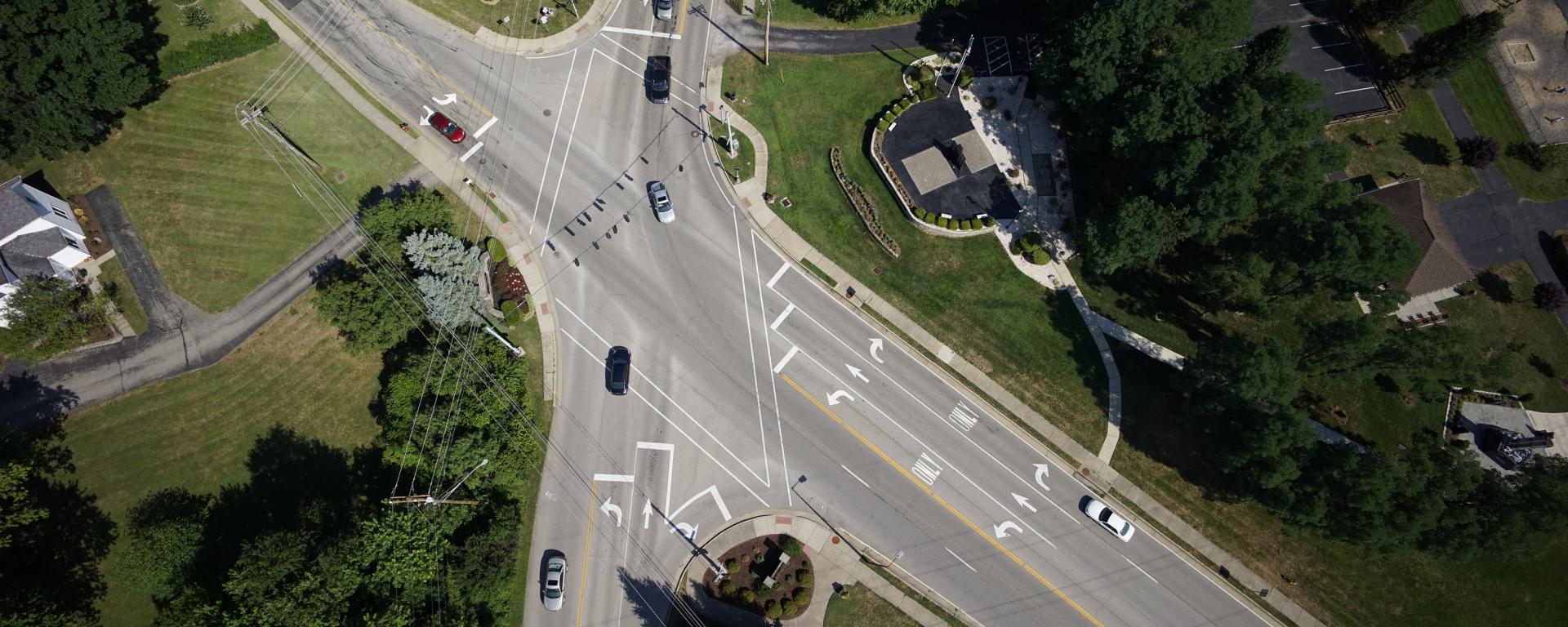 aerial photo of a roadway intersection with traffic striping on turn lanes