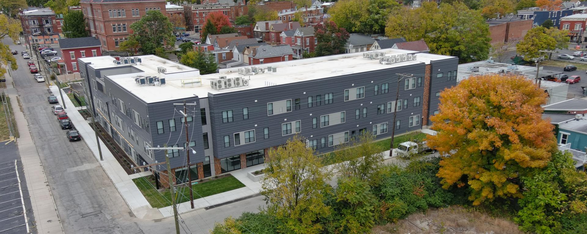 Aerial photo of a gray apartment building in urban neighborhood
