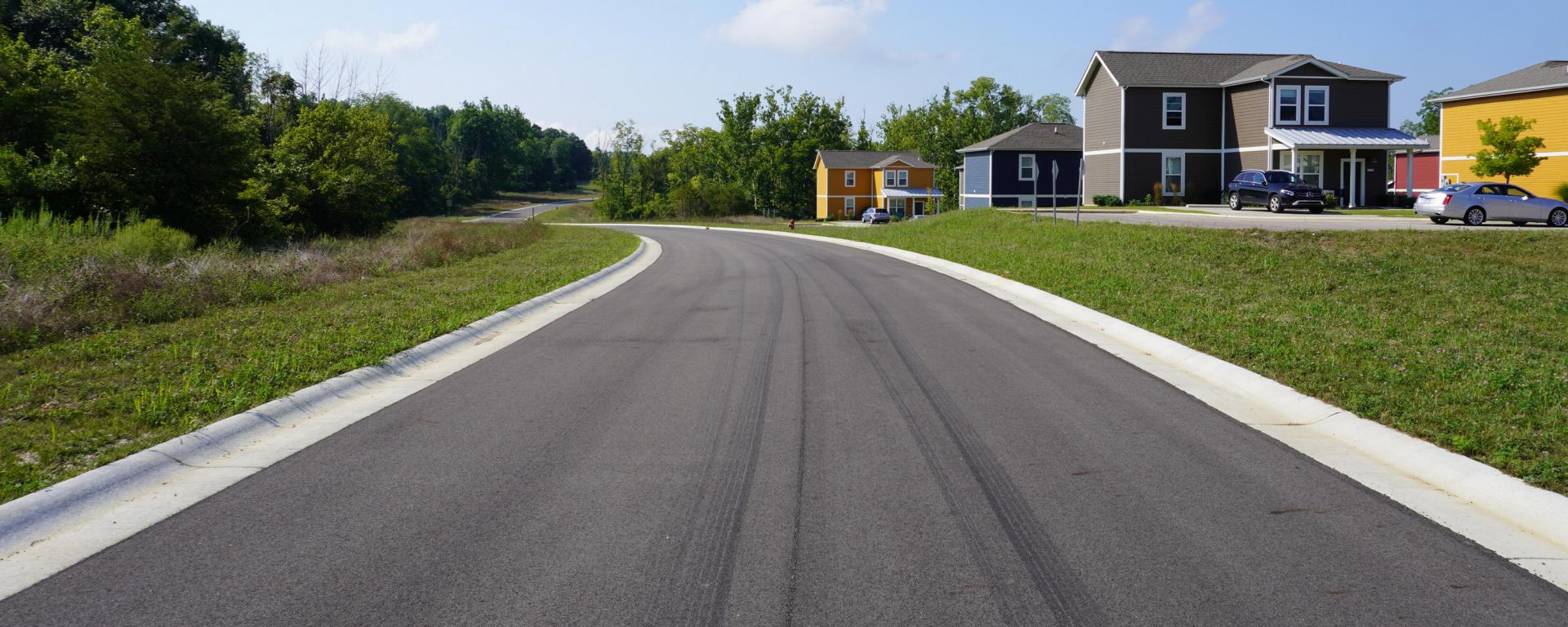 newly paved roadway with houses on one side