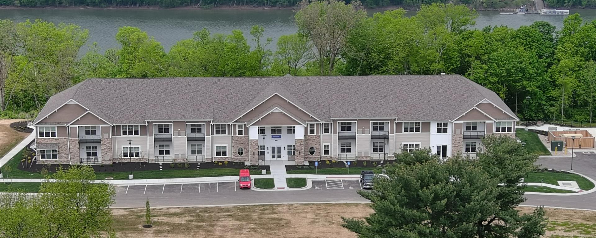 aerial photo of white senior living apartment building along the river