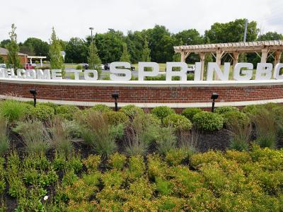 welcome sign with green plants surrounding