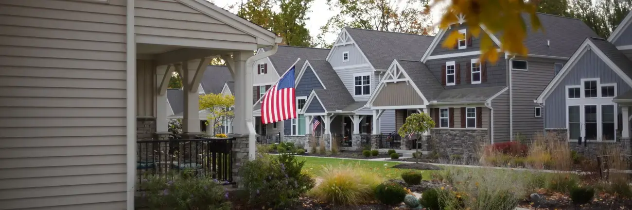 Aberlin Springs - Morrow, OH Suburban street with houses, American flag, and autumn leaves.